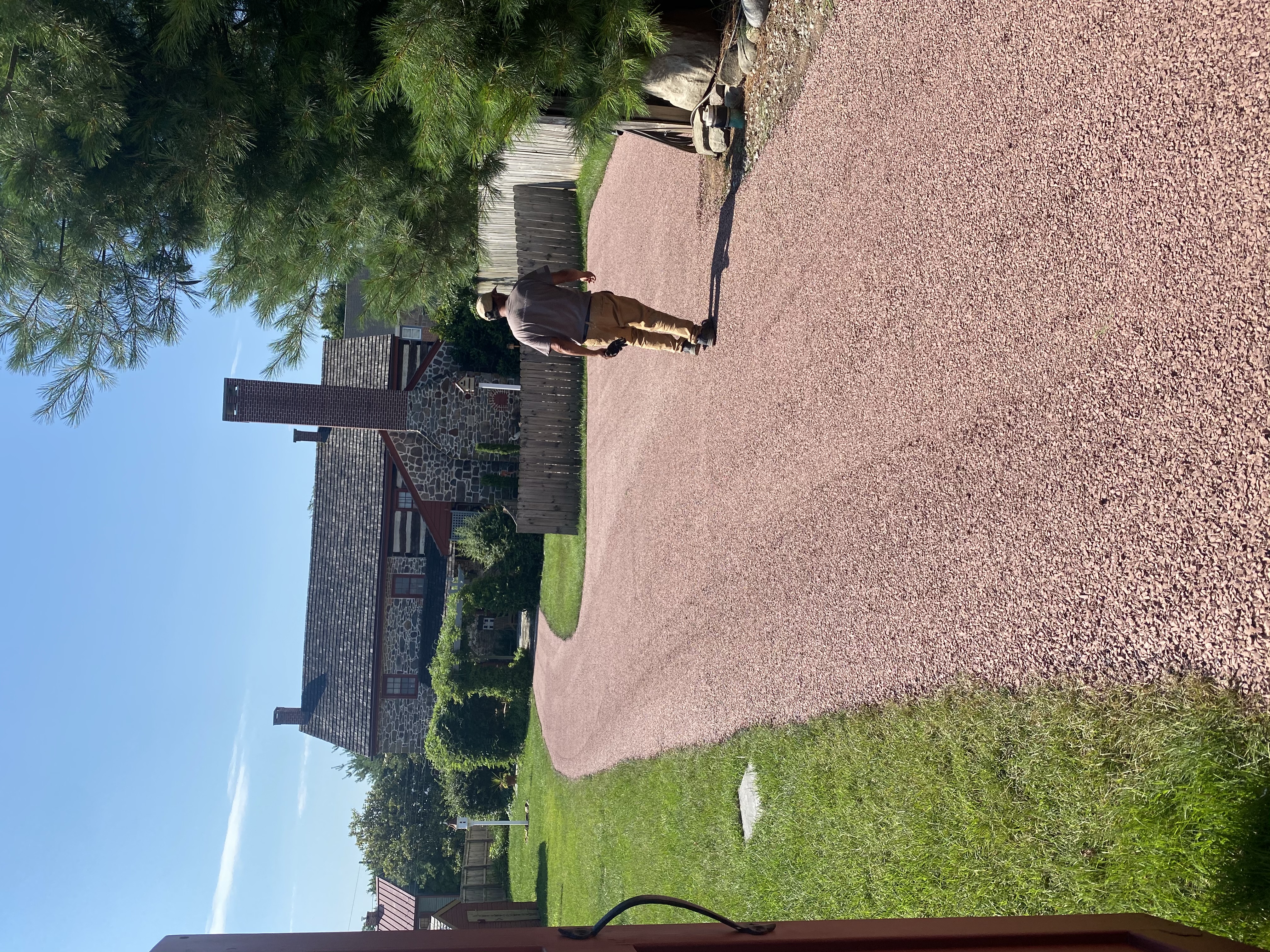 Close-up of a finished chip seal driveway with warm red aggregate
